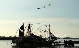 Tiga pesawat Sukhoi TNI AU melintas di atas kapal Phinisi di Makassar, Sulawesi Selatan.