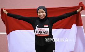 Pelari para Indonesia Karisma Evi Tiarani membentangkan bendera Merah Putih usai finis pada final 100 meter T63 Asian Para Games 2026 di Stadion Paloma Mizuho, Nagoya, Aichi, Jepang, Rabu (21/10/2026). Tiarani berhasil meraih medali emas usai finis pada urutan pertama dengan catatan waktu 14,59 detik serta membukukan catatan rekor dunia menurut laman resmi Asian Para Games 2026. 