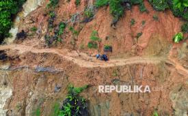 Warga membantu pengendara melintasi jalan yang tertimbun longsor di Nagari Anduriang, Kayu Tanam, Padang Pariaman, Sumatera Barat, Sabtu (27/12/2025). Jalan longsor sejak tiga pekan lalu itu dibuka secara gotong-royong oleh masyarakat setempat agar dapat dilewati, namun kondisi curah hujan tinggi dan longsor susulan membuat jalan penghubung kecamatan Lubuk Alung dan Kayu Tanam itu semakin berbahaya dilewati roda dua.  