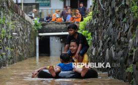 Warga beraktivitas saat banjir merendam permukiman di Kawasan Rawajati, Cawang, Kramat Jati, Jakarta Timur, Jumat (30/1/2026). Banjir dengan ketinggian 1 hingga 3,5 meter tersebut terjadi sejak pukul 02.00 WIB dini hari yang disebabkan oleh luapan sungai Ciliwung. Akibat banjir tersebut, aktivitas warga terhambat dan sebagian warga memilih bertahan di lantai dua rumahnya hingga air banjir surut.