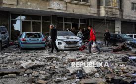 Warga Palestina melintas di depan mobil yang hancur akibat serangan udara Israel di Kota Gaza, Sabtu (31/1/2026). Setidaknya 12 orang syahid dalam serangan udara Israel di Gaza.