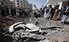 Warga Yaman memeriksa lokasi serangan udara yang dipimpin Saudi yang menargetkan posisi di Sanaa pada 2015.
