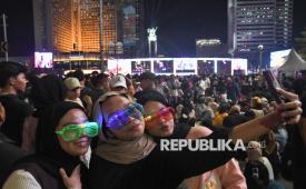 Sejumlah warga berswafoto saat car free night (malam bebas kendaran bermotor) di Kawasan Bundaran HI, Jakarta Pusat, Selasa (31/12/2024). Pemprov DKI menggelar perayaan pergantian tahun salah satunya di Bundaran HI bertajuk Kirana Jakarta 2025 dengen menampilkan pertunjukkan musik, pertunjukkan 800 unit drone show dan video mapping 3D. 