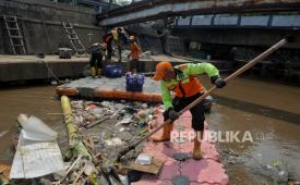 Petugas UPK Badan Air Dinas Lingkungan Hidup DKI Jakarta mengangkut sampah di aliran Kali Ciliwung. Dinas Bina Marga DKI membenahi dan membersihkan saluran air untuk cegah banjir.