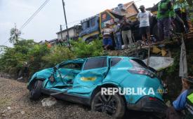 Warga mengamati taksi listrik Green SM yang rusak  akibat tertabrak KRL Commuter di Bekasi Timur, Jawa Barat, Selasa (28/4/2026). Kementerian Perhubungan akan melakukan evaluasi menyeluruh menyusul kecelakaan KRL dengan KA Argo Bromo di Stasiun Bekasi Timur. Evaluasi juga mencakup keterlibatan taksi asal Vietnam, Green SM, yang mogok perlintasan sebidang dan diduga menjadi pemicu awal insiden.