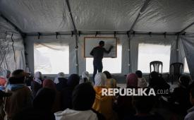 Siswa Palestina mengikuti pelajaran di dalam tenda darurat yang didirikan di Khan Younis, Jalur Gaza. Perang Israel di Gaza telah membuat anak-anak Palestina mengungsi, trauma, dan kehilangan kesempatan untuk mendapatkan pendidikan.