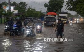 Sejumlah pengendara menerobos banjir (ilustrasi). BPBD Provinsi Sulawesi Barat mengeluarkan imbauan resmi bagi masyarakat, khususnya yang bermukim di kawasan pesisir, untuk mewaspadai potensi banjir rob atau genangan air laut ke daratan pada awal Januari 2026.