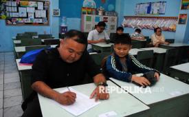 Orang tua murid mengisi daftar hadir saat pembagian rapor di SDN Polisi 4, Kota Bogor, Jawa Barat, Kamis (18/12/2025). Program Gerakan Ayah Mengambil Rapor ke Sekolah (Gemar) yang diluncurkan Kementerian Kependudukan dan Pembangunan Keluarga/Badan Kependudukan dan Keluarga Berencana Nasional (BKKBN) tersebut bertujuan untuk memperkuat peran ayah dalam pengasuhan dan pendidikan anak sejak dini. 