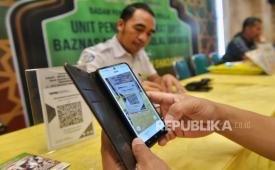 Jamaah membayar zakat fitrah melalui layanan Qris di Masjid Istiqlal, Jakarta, Sabtu (6/4/2024). Unit Pengumpul Zakat (UPZ) Baznas Masjid Istiqlal membuka layanan pembayaran zakat fitrah berupa 3,5 liter beras atau uang senilai Rp50.000 yang berlangsung hingga malam takbiran.