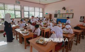 Siswa bersiap menyantap hidangan Makanan Bergizi Gratis (MBG) di SDN Pejaten Barat 01 Pagi, Jakarta Selatan, Senin (29/9/2025). SDN Pejaten Barat 01 Pagi mengambil langkah antisipatif dengan melibatkan komite orang tua murid untuk mengawasi proses pendistribusian MBG dari dapur SPPG hingga mengecek kualitas makanan.