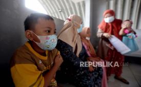 Seorang anak laki-laki Indonesia menunggu setelah menerima vaksin Covid-19 saat vaksinasi untuk anak-anak berusia antara enam hingga sebelas tahun di kantor polisi di sebuah under pass di Pamulang, Banten, Indonesia, 06 Januari 2022. 
