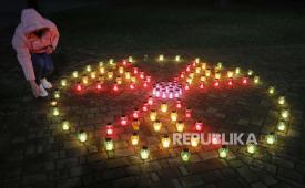Warga Ukraina menyalakan lilin yang membentuk simbol radiasi di dekat monumen peringatan yang meninggal selama pembersihan setelah bencana pembangkit listrik tenaga nuklir Chernobyl.