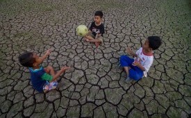 Sejumlah anak memanfaatkan areal persawahan yang terdampak kekeringan untuk bermain bola di Cibiru Hilir, Kabupaten Bandung, Jawa Barat, Rabu (3/7/2019).