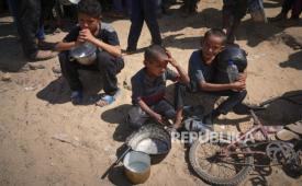 Warga Palestina berjuang untuk mendapatkan sumbangan makanan di dapur komunitas di Khan Younis, di selatan Jalur Gaza, Jumat, 9 Mei 2025.