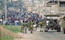 Warga Palestina berhadap-hadapan dengan pasukan Israel pada Intifada Pertama.