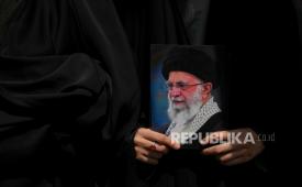 Seorang pengunjuk rasa memegang poster Pemimpin Tertinggi Iran Ayatollah Ali Khamenei di Teheran, Iran, Jumat, 20 Juni 2025.