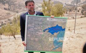 Menteri Keuangan Israel Bezalel Smotrich memegang peta yang menunjukkan proyek pemukiman E1 saat konferensi pers di dekat pemukiman Maale Adumim, di Tepi Barat yang diduduki Israel, Kamis, 14 Agustus 2025.