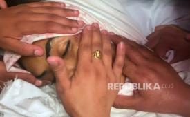 Keluarga, kerabat dan teman membelai wajah jurnalis Mariam Dagga (33 tahun) saat pemakamannya setelah dia terbunuh dalam serangan Israel di Rumah Sakit Nasser di Khan Younis, Jalur Gaza selatan, Senin, 25 Agustus 2025.