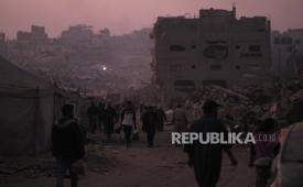 Warga Palestina berjalan melewati kehancuran akibat serangan udara dan darat Israel di lingkungan Sheikh Radwan di Kota Gaza, Senin, 10 November 2025.
