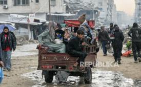 Keluarga menaiki gerobak di tengah hujan di Gaza, Senin, 15 Desember 2025.