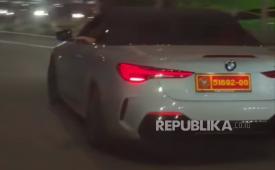 Mobil sedan BMW warna putih memakai pelat dinas Kemenhan.