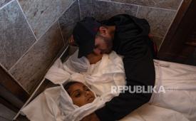 Ayah dari dua gadis  yang syahid dibunuh Israel di Khan Younis berduka di samping jenazah mereka di Rumah Sakit Nasser, Gaza, 4 Februari 2026.