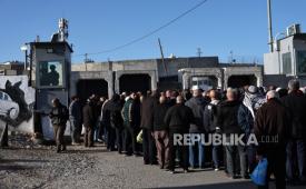 Tentara Israel berjaga ketika warga Palestina mengantri untuk menyeberang di pos pemeriksaan Israel di Qalandia antara Tepi Barat dan Yerusalem, 20 Februari 2026