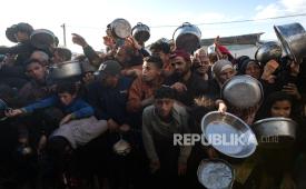 Pengungsi Palestina berebut makanan berbuka puasa yang didistribusikan oleh dapur amal selama bulan suci Ramadhan, di Khan Younis, Jalur Gaza selatan, 26 Februari 2026. 