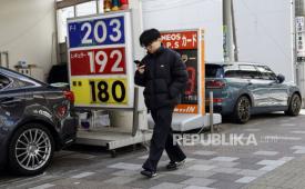 Seorang pejalan kaki berjalan melewati pompa bensin di Tokyo, Jepang, 16 Maret 2026. Pada 16 Maret 2026, pemerintah Jepang mengumumkan mulai melepaskan cadangan minyaknya sebagai tanggapan atas blokade de facto di Selat Hormuz. 