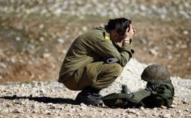 Seorang tentara tempur wanita muda Israel beristirahat setelah mengikuti latihan rintangan.