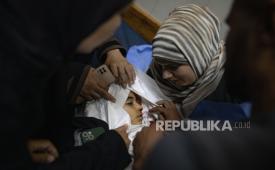 Kerabat menangis di samping jenazah Julie Al-Balawi (8 tahun) di dalam Rumah Sakit Nasser di Khan Yunis, di Jalur Gaza selatan, pada 21 Juni 2026. Ia syahid akibat serangan Israel yang menargetkan pantai di Khan Yunis.