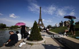 Orang-orang berlindung dari panas dengan payung di Air Mancur Trocadero dekat Menara Eiffel, di Paris, Prancis, 20 Juni 2026. Gelombang panas yang hebat melanda Eropa Barat dan Tengah, mendorong suhu jauh di atas normal musiman pada pertengahan Juni. 