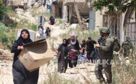 Warga Palestina yang mengungsi membawa barang-barang mereka melintasi kamp pengungsi Tulkarem di kota Tulkarm, Tepi Barat, pada 17 Juni 2026, saat militer Israel melanjutkan pengerahan pasukan di seluruh wilayah kota tersebut.