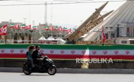 Warga Iran berkendara di samping rudal Iran, Zolfaghar, yang dipamerkan di Lapangan Azadi di Teheran, Iran, pada 24 Juli 2026.