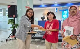 Perwakilan BCA menyerahkan dokumen kepada peserta kegiatan sertifikasi halal gratis bagi pelaku UMKM. 