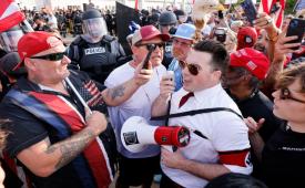 Seorang pengunjuk rasa yang mengenakan ban lengan dengan simbol swastika Nazi berbicara melalui pengeras suara di luar Perpustakaan Henry Ford Centennial dalam sebuah demonstrasi anti-Muslim dengan tajuk Christian Crusade March di Dearborn, Michigan, pada 18 Agustus 2026.