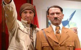 Aktivis media sosial Permadi Arya alias Abu Janda berpose salam Nazi dengan patung Hitler.