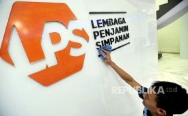 Karyawan membersihkan logo Lembaga Penjamin Simpanan (LPS) di Jakarta.