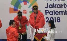 Ketua Inasgoc Erick Thohir mengalungkan medali kepada Pesilat Indoensia Yola Primadona Jampil dan Hendy pada final cabang pencak silat kelas artistik ganda putra Asian Games 2018 di Padepokan Pencak Silat TMII, Jakarta, Senin (27/8). 