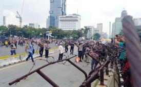 Massa aksi saling lempar dengan massa lainnya yang melakukan aksi di Patung Kuda, Jalan Medan Merdeka Barat, Kecamatan Gambir, Jakarta Pusat, Jumat (19/4/2024).