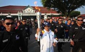 Menteri Luar Negeri (Menlu), Retno Marsudi saat membawa obor api Asian Games di Yogyakarta