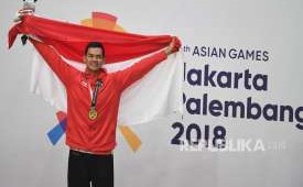 Pesilat Indonesia peraih medali emas Aji Bangkit Pamungkas berpose usai upacara penyerahan medali nomor Kelas I Putra Asian Games 2018 di Padepokan Pencak Silat Taman Mini Indonesia Indah (TMII), Jakarta, Senin (27/8).