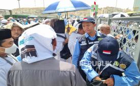 Petugas Indonesia membantu jamaah haji Indonesia yang pulang ke hotelnya selepas shalat Jumat. 