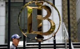 Petugas keamanan melintas di dekat logo Bank Indonesia (BI).