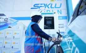 Petugas SPKLU mengisi energi listrik ke sebuah EV.