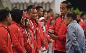 Presiden Joko Widodo (kedua kanan) bersama Wakil Presiden Jusuf Kalla melihat isi buku tabungan saat pemberian bonus kepada atlet peraih medali di Istana Negara, Jakarta, Minggu (2/9). 
