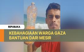 Seorang warga Gaza menerima botol berisi bantuan yang dikirimkan dari Mesir.