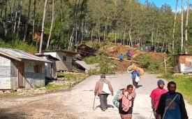 Warga berjalan membawa barang-barangnya di wilayah lokasi longsor yang melanda Desa Kaokalam, Provinsi Enga, Papua Nugini, Jumat, 24 Mei 2024.