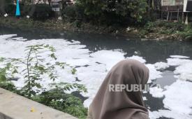 Warga melihat Kali Sunter, Jakarta Utara, yang berbusa akibat pencemaran, Selasa (19/8/2025).