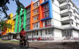 Warga melintas di depan rumah susun sederhana sewa (rusunawa) di Surabaya. 